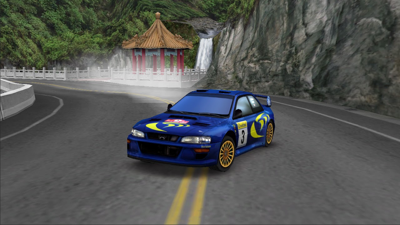 A blue rally car sliding on a tarmac road beside a pagoda and waterfall