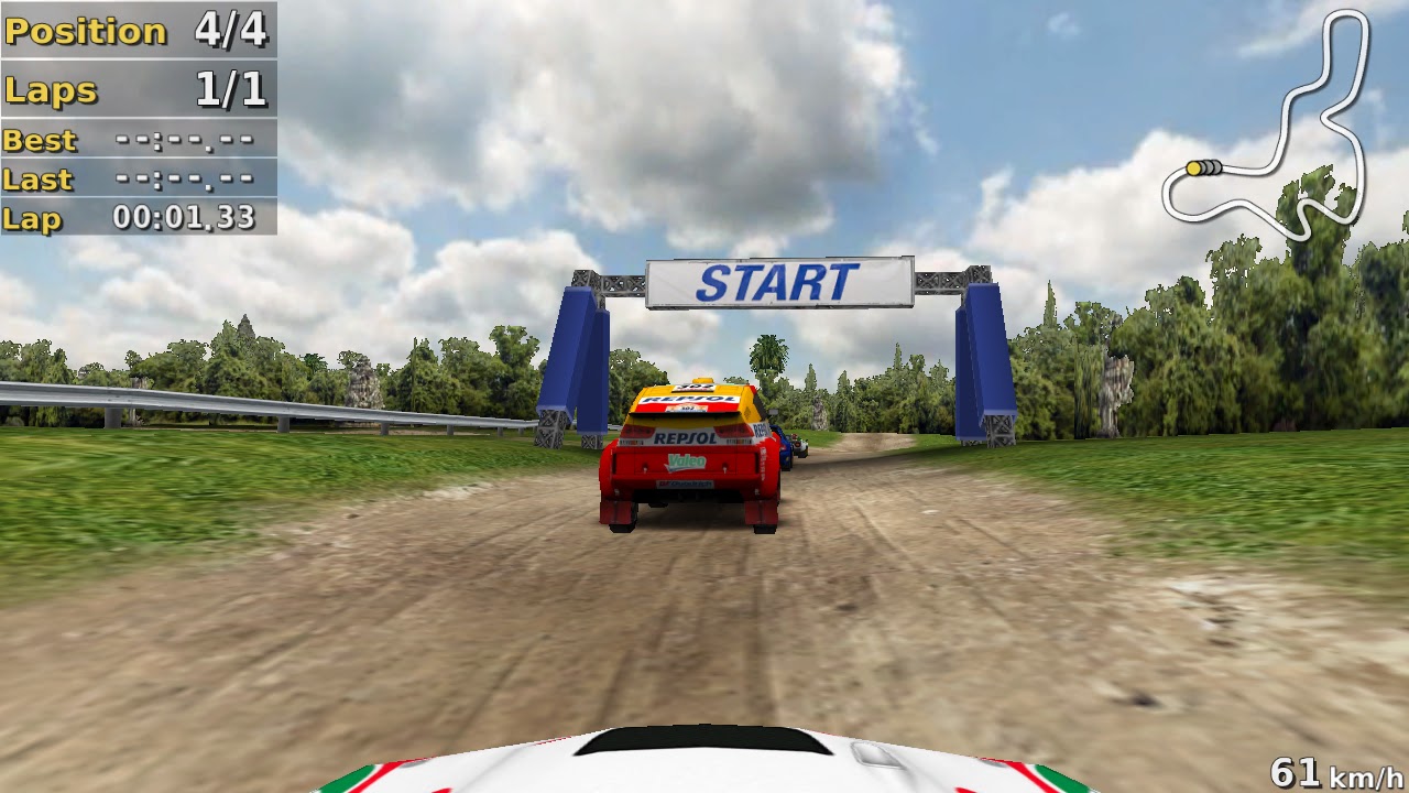 A rally car lined up under a blue START gate on a dirt stage